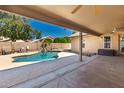 A covered patio overlooks the pool and waterfall feature in the backyard at 632 W Natal Cir, Mesa, AZ 85210