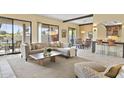 Open-concept living room featuring a large sectional sofa, natural light, and seamless access to the dining area at 7552 N San Manuel Rd, Scottsdale, AZ 85258
