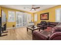 Cozy living room with a ceiling fan, hardwood floors, plantation shutters, and comfortable leather seating at 829 S Roanoke St, Gilbert, AZ 85296