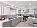 Well-lit kitchen with modern appliances, gray cabinets, and stylish backsplash at 850 S River Dr # 1085, Tempe, AZ 85281