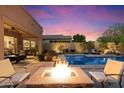Entertain guests around the fire pit with views of the pool and covered patio at 8733 E Jacaranda St, Mesa, AZ 85207