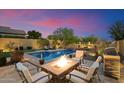 Enjoy outdoor living with a cozy fire pit, pool, and grill in this private backyard at 8733 E Jacaranda St, Mesa, AZ 85207