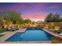 Relax in this beautiful pool surrounded by lush landscaping and a tranquil water feature at 8733 E Jacaranda St, Mesa, AZ 85207