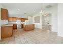 Eat-in kitchen features wood cabinets, white appliances, tile flooring, and decorative lighting at 89 S 151St Ave, Goodyear, AZ 85338