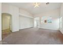 Spacious living room showcasing neutral carpet, and an arched entrance to other rooms at 89 S 151St Ave, Goodyear, AZ 85338