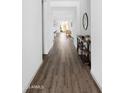 Long hallway with hardwood flooring, leading to an open-concept living space, bathed in natural light at 948 E La Mirada Dr, Phoenix, AZ 85042