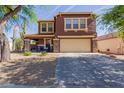 Inviting two-story home with desert landscaping, front porch seating, and a spacious driveway leading to a two-car garage at 10561 E Plata Ave, Mesa, AZ 85212