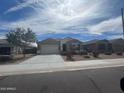 View of a single-story home, with a two car garage and landscaped front yard with decorative rock at 13549 W Paso Trl, Peoria, AZ 85383