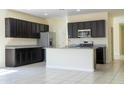 Kitchen with granite countertops, stainless steel appliances, and espresso colored cabinets at 13549 W Paso Trl, Peoria, AZ 85383