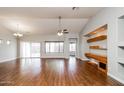 Spacious living room with hardwood floors, a ceiling fan, and built-in shelving for a modern look at 1399 E Anna Dr, Casa Grande, AZ 85122