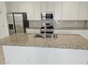 Beautiful kitchen island with stainless steel sink, granite countertop, and modern appliances at 14224 W Hackamore Dr, Surprise, AZ 85387