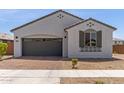 Well-maintained single-story home with a brick driveway, gray stucco exterior, and neat landscaping at 14269 W El Cortez Pl, Surprise, AZ 85387