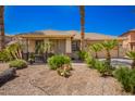 Charming single-story home with desert landscaping, palm trees, and tiled roof at 15471 W Post Cir, Surprise, AZ 85374