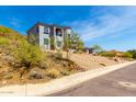 View of a gray stucco home featuring desert landscaping on a gently sloping hillside at 2110 E Kerry Ln, Phoenix, AZ 85024