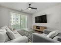 Inviting living room featuring modern ceiling fan, balcony access, and entertainment center at 2511 W Queen Creek Rd # 266, Chandler, AZ 85248