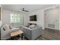 Cozy living room featuring neutral decor, ceiling fan, balcony access, and sleek entertainment center at 2511 W Queen Creek Rd # 266, Chandler, AZ 85248