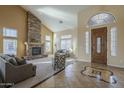 Inviting living room with high ceilings, a stone fireplace, and ample natural light at 27316 N Covered Wagon Rd, Phoenix, AZ 85085