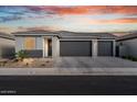 Charming single-story home with a three-car garage, desert landscaping, and a paver driveway at 3187 E Pineapple Rd, San Tan Valley, AZ 85143