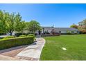 Beautiful home exterior with a lush green lawn, mature trees, and a charming walkway leading to the entrance at 4030 N 54Th Pl, Phoenix, AZ 85018