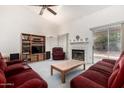 Cozy living room with a fireplace, vaulted ceilings, and comfortable seating arrangement at 4102 W Fallen Leaf Ln, Glendale, AZ 85310