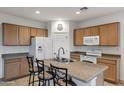 Kitchen showcasing a functional island with seating and modern appliances at 42335 W Waterfall Way, Maricopa, AZ 85138