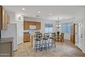 Bright kitchen featuring an island with bar stool seating, a dining area, and tile flooring at 42335 W Waterfall Way, Maricopa, AZ 85138