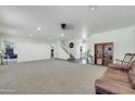 Expansive living room featuring neutral carpet, staircase, and ample space for entertaining at 44314 W Mescal St, Maricopa, AZ 85138