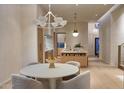 Dining area with seating for four, modern chandelier, and a view into the open kitchen at 5101 N Casa Blanca Dr # 223, Paradise Valley, AZ 85253