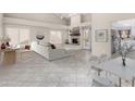 Bright, open-concept living room with vaulted ceilings, fireplace, and tile floors, seamlessly integrates the dining area at 563 N Spanish Springs Dr, Chandler, AZ 85226