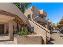 Tan two-story condo building with stairs leading to upper units and well-maintained landscaping at 7129 E Broadway Rd # 72, Mesa, AZ 85208