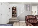 Entryway to living room features shelving, a carpeted staircase, and tile flooring at 7506 N 47Th Dr, Glendale, AZ 85301