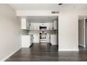 Bright kitchen with stainless steel appliances, white cabinets, and gray wood-look flooring at 7920 E Camelback Rd # 110, Scottsdale, AZ 85251