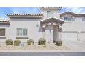 Charming stucco home with gravel landscaping, a covered entryway, and an attached garage at 7978 W Zoe Ella Way, Peoria, AZ 85382