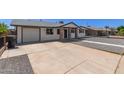 Exterior view of home with a large concrete driveway and easy garage access at 119 E Hampton Ave, Mesa, AZ 85210