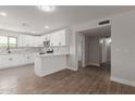 Open kitchen featuring white cabinets, marble backsplash, stainless steel appliances, and breakfast bar at 119 E Hampton Ave, Mesa, AZ 85210