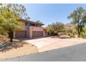 Home exterior featuring a large driveway with a three-car garage and tile roof at 1305 Coyote Pass Pass, Carefree, AZ 85377