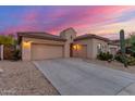 Desert home showcasing a spacious three-car garage, neutral color palette, and low maintenance landscaping at 13569 S 175Th Dr, Goodyear, AZ 85338