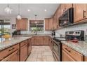 Well-appointed kitchen featuring granite countertops, stainless steel appliances, and travertine flooring at 14294 W Edgemont Ave, Goodyear, AZ 85395