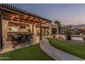Inviting outdoor living area with bar seating, pergola and string lights for evening enjoyment at 14294 W Edgemont Ave, Goodyear, AZ 85395