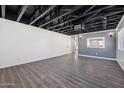 Spacious basement with laminate floors, white walls, gray accent wall, and pass-through to another room at 1466 E Avenida Fresca --, Casa Grande, AZ 85122