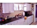 White cabinets and stainless steel sink are features in this kitchen at 1837 W Roma Ave, Phoenix, AZ 85015