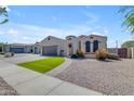 Lovely desert home featuring a well-manicured lawn, attractive xeriscaping, and a convenient two-car garage at 18437 E Celtic Manor Dr, Queen Creek, AZ 85142