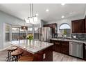 Bright kitchen with granite island, stainless steel appliances, dark wood cabinets and breakfast nook at 18643 N 73Rd Ave, Glendale, AZ 85308