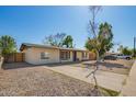 Inviting single-story home featuring a neutral color scheme, long driveway, and xeriscaped yard at 1919 W Fairmount Ave, Phoenix, AZ 85015
