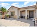 Covered front patio with seating area, providing a relaxing outdoor space with desert landscaping at 20473 N Desert Sage Ln, Surprise, AZ 85374
