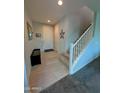Inviting foyer features neutral tile flooring, a coat rack, and a staircase with white railing at 22026 N 28Th Pl, Phoenix, AZ 85050