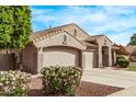 Beautiful home exterior featuring a three-car garage, desert landscaping, and mature shrubbery at 2233 S Nielson St, Gilbert, AZ 85295