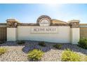 Entrance to an active adult community with a stone sign and well-maintained landscaping at 22940 W Desert Bloom St, Buckeye, AZ 85326