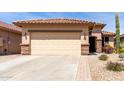 Home exterior featuring a wide driveway and low-maintenance desert landscaping at 22940 W Desert Bloom St, Buckeye, AZ 85326