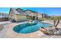 Backyard pool with rock features, next to a patio on a sunny day at 248 S 167Th Dr, Goodyear, AZ 85338